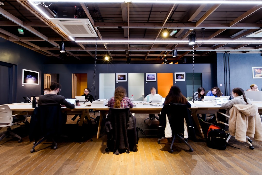 An image showing a small, modern office with a team of professionals working together in a large collaborative space. The image portrays openness and collaboration to work more productively with a solid support network.